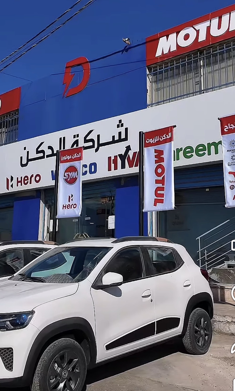 The Diken main branch in Amman, red D on the building, partner banners along the front