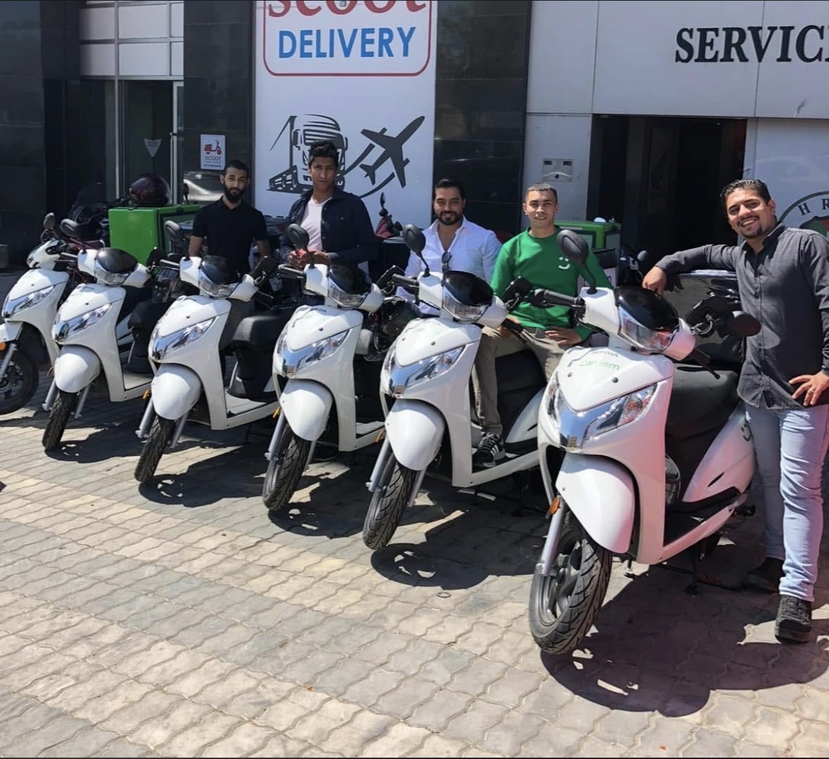 The first six delivery scooters and the team beside them, 2009